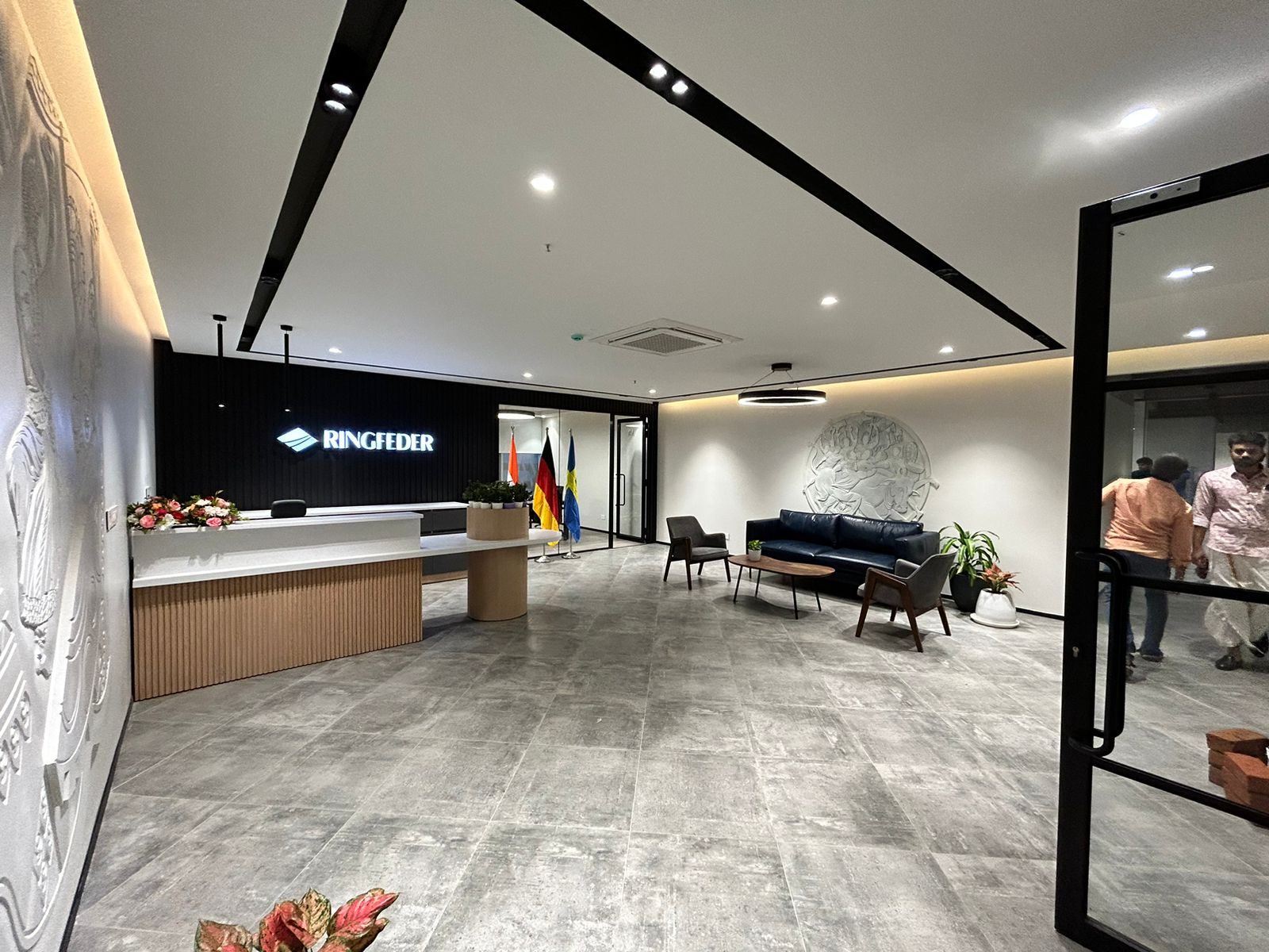 Ringfeder reception with a backlit sign, fluted timber desk and cast relief wall